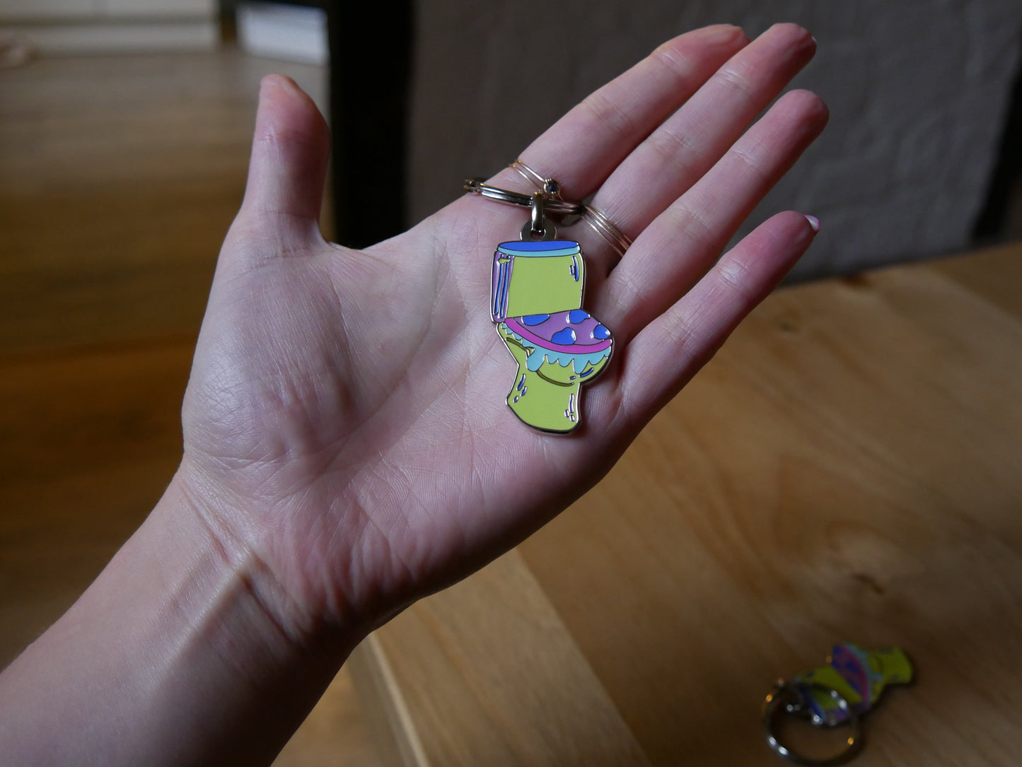 Porté-clés toilettes "Les larmes des ouin-ouins" en émail avec attache métal