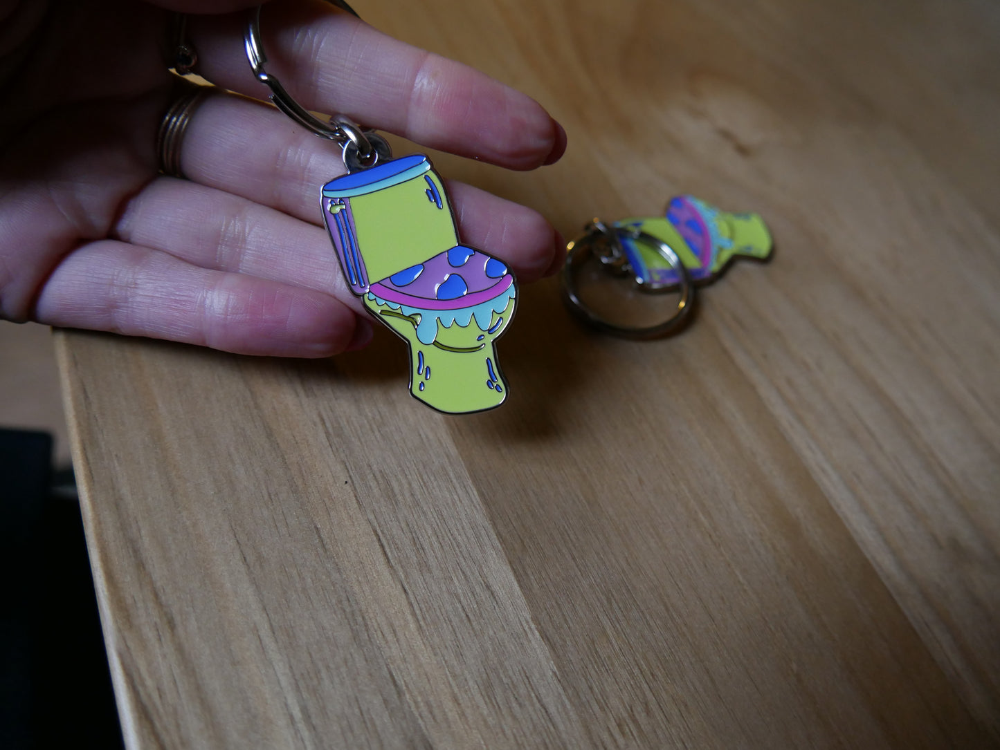 Porté-clés toilettes "Les larmes des ouin-ouins" en émail avec attache métal